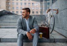 Businessman with bike having lunch at the office