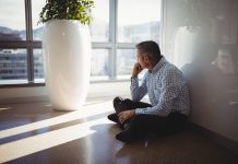 Thoughtful executive sitting on floor