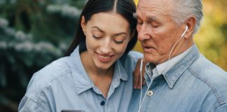Mujer enseñándole al señor mayor a usar los aparatos electrónicos para abuelitos