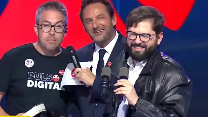El Presidente Boric adquiere la icónica gabardina de Emmanuel en una subasta. El Presidente Boric adquiere la icónica gabardina de Emmanuel en una subasta.